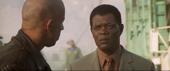 Movie still from “xXx” (2002), directed by Rob Cohen – A man in a suit and tie talking to another man in a suit and tie; Close Up shot, Over the shoulder angle