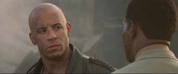 Movie still from “xXx” (2002), directed by Rob Cohen – A bald man in a military jacket looks at the camera; Close Up shot, Over the shoulder angle