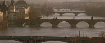 Movie still from “xXx” (2002), directed by Rob Cohen – A view of a river with a bridge in the background; Extreme Wide shot, High angle