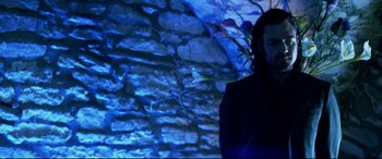 Movie still from “xXx” (2002), directed by Rob Cohen – A woman standing in front of a stone wall; Medium shot, Low angle