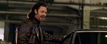 Movie still from “xXx” (2002), directed by Rob Cohen – A man in a leather jacket is driving a car; Medium shot, Low angle