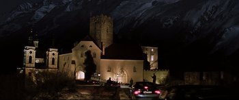 Movie still from “xXx” (2002), directed by Rob Cohen – A church is lit up at night with cars parked in front of it; Extreme Wide shot, Low angle