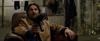 Movie still from “xXx” (2002), directed by Rob Cohen – A man sitting in a chair holding a remote control; Close Up shot, Low angle