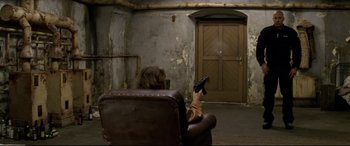 Movie still from “xXx” (2002), directed by Rob Cohen – A man sitting in a chair holding a remote control; Wide shot, High angle