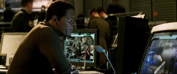Movie still from “xXx” (2002), directed by Rob Cohen – A man sitting in front of a computer monitor; Medium shot, Over the shoulder angle
