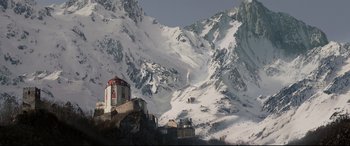 Movie still from “xXx” (2002), directed by Rob Cohen – A snowy mountain with a building on top of a hill; Extreme Wide shot, Low angle