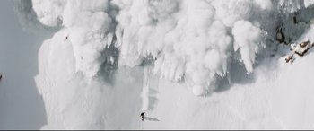 Movie still from “xXx” (2002), directed by Rob Cohen – A person is skiing down a mountain of snow; Extreme Wide shot, Overhead angle