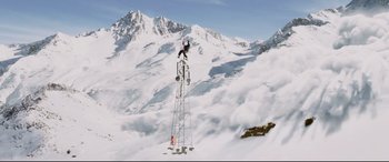 Movie still from “xXx” (2002), directed by Rob Cohen – A person on a snowboard on top of a tower in the middle of a snowy mountain; Extreme Wide shot, Low angle