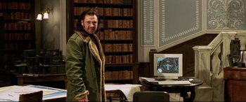 Movie still from “xXx” (2002), directed by Rob Cohen – A man standing in front of a computer in a library; Medium shot, Over the shoulder angle