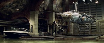 Movie still from “xXx” (2002), directed by Rob Cohen – A woman standing in front of an airplane in an industrial setting; Extreme Wide shot, High angle