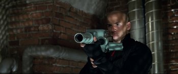 Movie still from “xXx” (2002), directed by Rob Cohen – A man holding a gun in his hands; Medium shot, Low angle