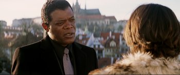 Movie still from “xXx” (2002), directed by Rob Cohen – A man in a suit and tie talking to a woman in front of a castle; Close Up shot, Over the shoulder angle