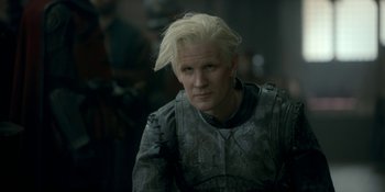 Movie still from “House of the Dragon” (2022), created by George R.R. Martin – A man with blonde hair wearing a suit of armor; Close Up shot, Over the shoulder angle