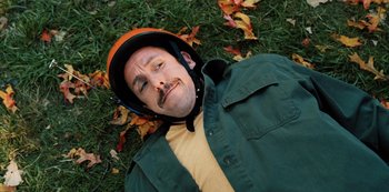Movie still from “Hubie Halloween” (2020), directed by Steven Brill – A man laying in the grass wearing a motorcycle helmet; Close Up shot, Overhead angle