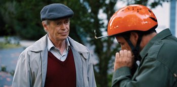 Movie still from “Hubie Halloween” (2020), directed by Steven Brill – An older man wearing a hat and a jacket; Close Up shot, Over the shoulder angle