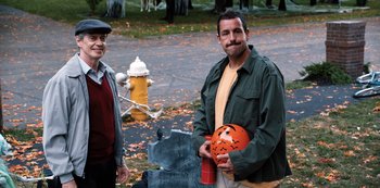 Movie still from “Hubie Halloween” (2020), directed by Steven Brill – A man holding an orange jack - o - lantern next to a fire hydrant; Medium shot, High angle