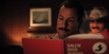 Movie still from “Hubie Halloween” (2020), directed by Steven Brill – A man sitting in front of an open book; Close Up shot, High angle