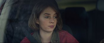 Movie still from “Human Capital” (2019), directed by Marc Meyers – A woman sitting in the back seat of a car; Close Up shot, Over the shoulder angle
