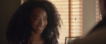 Movie still from “Human Capital” (2019), directed by Marc Meyers – A person with a smile on their face; Close Up shot, Over the shoulder angle