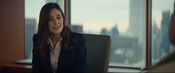 Movie still from “Human Capital” (2019), directed by Marc Meyers – A woman sitting in a chair in front of a window; Medium shot, Over the shoulder angle