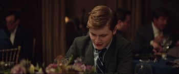 Movie still from “Human Capital” (2019), directed by Marc Meyers – A young man sitting at a table with a glass of wine; Close Up shot, Over the shoulder angle