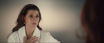 Movie still from “Human Capital” (2019), directed by Marc Meyers – A person wearing a white robe; Close Up shot, High angle