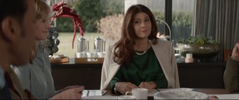 Movie still from “Human Capital” (2019), directed by Marc Meyers – A woman sitting at a table with a cup of coffee in front of her; Medium shot, Over the shoulder angle