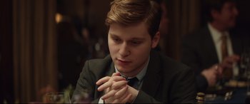 Movie still from “Human Capital” (2019), directed by Marc Meyers – A man in a suit and tie clasps his hands; Close Up shot, Over the shoulder angle