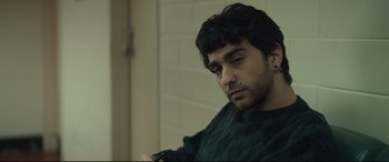 Movie still from “Human Capital” (2019), directed by Marc Meyers – A man sitting in front of a brick wall; Close Up shot, Over the shoulder angle