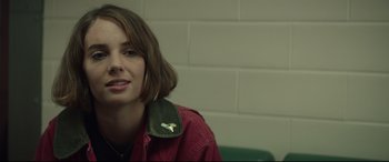 Movie still from “Human Capital” (2019), directed by Marc Meyers – A young woman wearing a red jacket with a green collar; Close Up shot, Over the shoulder angle