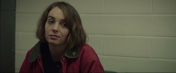 Movie still from “Human Capital” (2019), directed by Marc Meyers – A woman sitting in front of a brick wall; Close Up shot, Over the shoulder angle