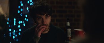 Movie still from “Human Capital” (2019), directed by Marc Meyers – A man sitting in front of a bottle of beer; Close Up shot, Over the shoulder angle