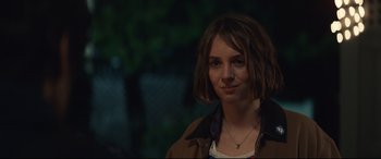 Movie still from “Human Capital” (2019), directed by Marc Meyers – A woman with short brown hair wearing a brown jacket; Close Up shot, Over the shoulder angle