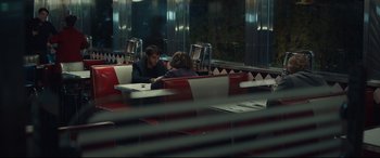 Movie still from “Human Capital” (2019), directed by Marc Meyers – Two people sitting at a booth in a restaurant; Medium shot, Over the shoulder angle
