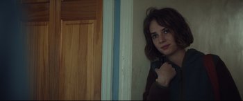 Movie still from “Human Capital” (2019), directed by Marc Meyers – A woman leaning against a wall holding a cell phone in her hand; Close Up shot, Over the shoulder angle