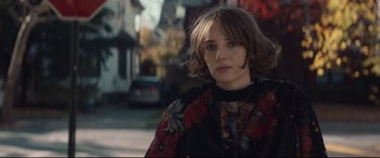 Movie still from “Human Capital” (2019), directed by Marc Meyers – A young woman in a black and red floral jacket; Close Up shot, Over the shoulder angle