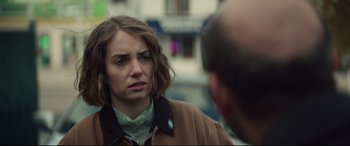 Movie still from “Human Capital” (2019), directed by Marc Meyers – A woman in a brown jacket is looking at a man; Close Up shot, Over the shoulder angle