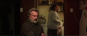 Movie still from “Hunt for the Wilderpeople” (2016), directed by Taika Waititi – An older man and a younger woman in a kitchen; Medium shot, Over the shoulder angle