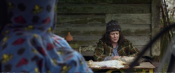Movie still from “Hunt for the Wilderpeople” (2016), directed by Taika Waititi – A woman sitting at a table cutting a cake; Medium shot, Over the shoulder angle