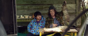 Movie still from “Hunt for the Wilderpeople” (2016), directed by Taika Waititi – A woman and a boy sitting at a table; Medium shot, Over the shoulder angle