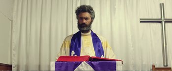 Movie still from “Hunt for the Wilderpeople” (2016), directed by Taika Waititi – A man with a beard and a purple and red robe; Medium shot, Low angle