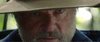 Movie still from “Hunt for the Wilderpeople” (2016), directed by Taika Waititi – A man with a beard and a hat; Extreme Close Up shot, Low angle