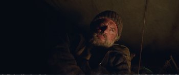 Movie still from “Hunt for the Wilderpeople” (2016), directed by Taika Waititi – A man with a beard and a hat is looking at the camera; Close Up shot, Low angle