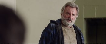 Movie still from “Hunt for the Wilderpeople” (2016), directed by Taika Waititi – An old man with a beard and a beard is looking at the camera; Close Up shot, Low angle