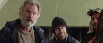 Movie still from “Hunt for the Wilderpeople” (2016), directed by Taika Waititi – Two men standing next to each other in front of a brick wall; Close Up shot, Low angle