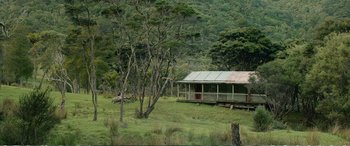 Movie still from “Hunt for the Wilderpeople” (2016), directed by Taika Waititi – An old cabin in the middle of a green field; Extreme Wide shot, High angle