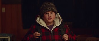 Movie still from “Hunt for the Wilderpeople” (2016), directed by Taika Waititi – A young boy wearing a plaid jacket and a hat; Close Up shot, Low angle