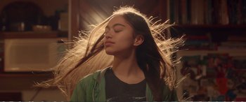 Movie still from “Hunt for the Wilderpeople” (2016), directed by Taika Waititi – A woman with her eyes closed with her hair blowing in the wind; Close Up shot, Low angle