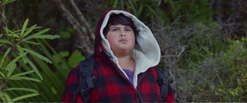Movie still from “Hunt for the Wilderpeople” (2016), directed by Taika Waititi – A young girl wearing a red and black jacket; Close Up shot, Low angle