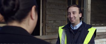 Movie still from “Hunt for the Wilderpeople” (2016), directed by Taika Waititi – A man in a yellow vest talking to another man; Close Up shot, Over the shoulder angle